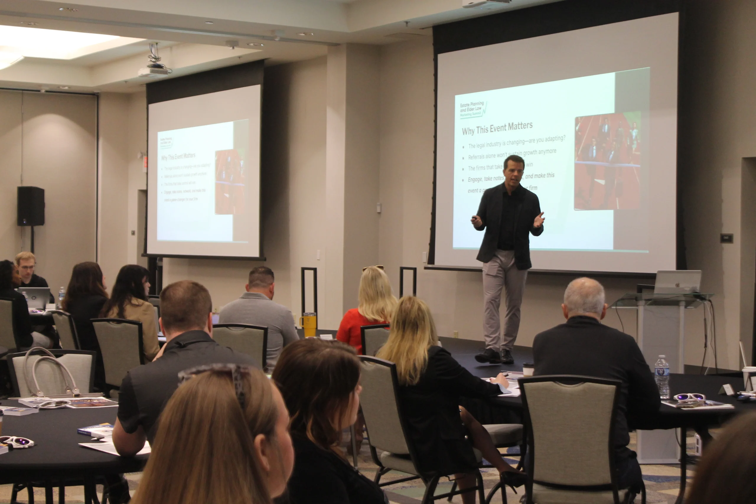 A speaker presenting on stage at the Summit